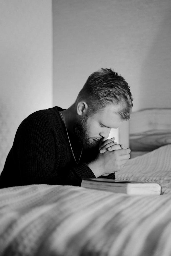 Grayscale Photo of a Man Praying