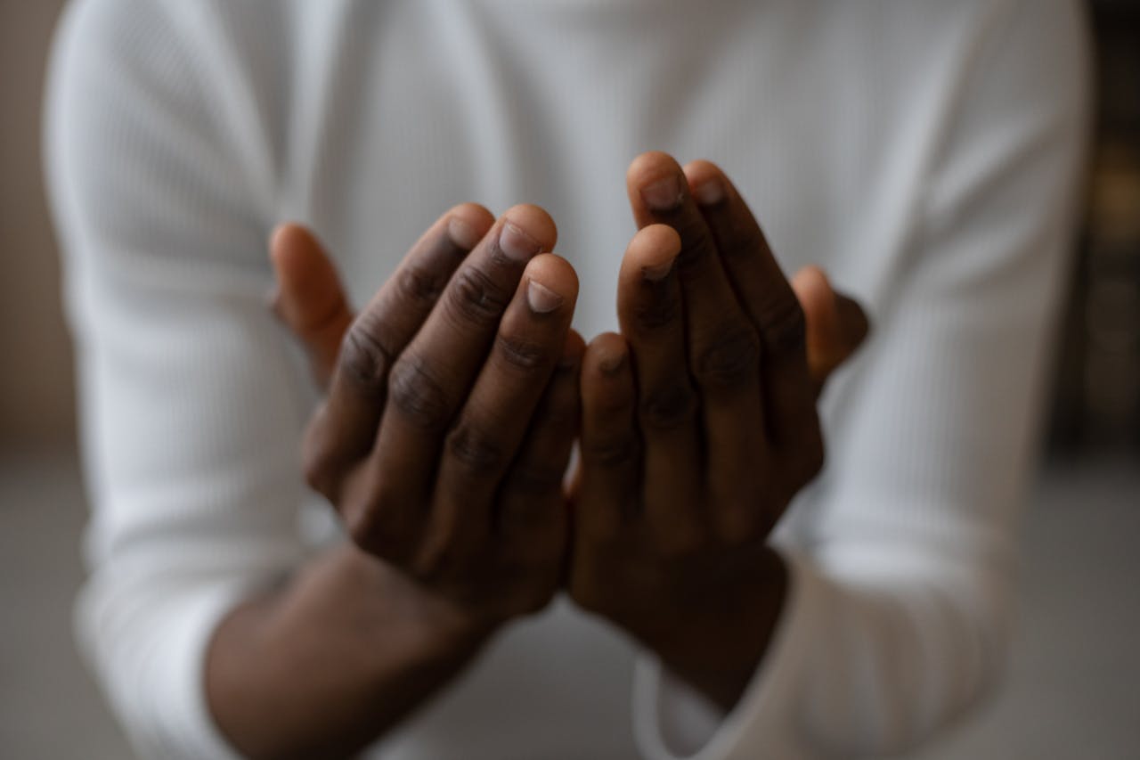 Crop black man praying at home